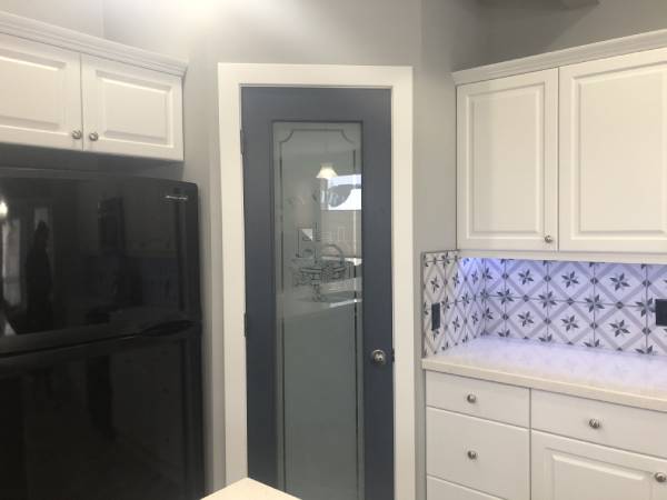 Okotoks modern two-tone white kitchen with navy pantry door