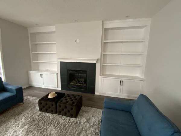 White painted fireplace mantel and built-in shelving unit