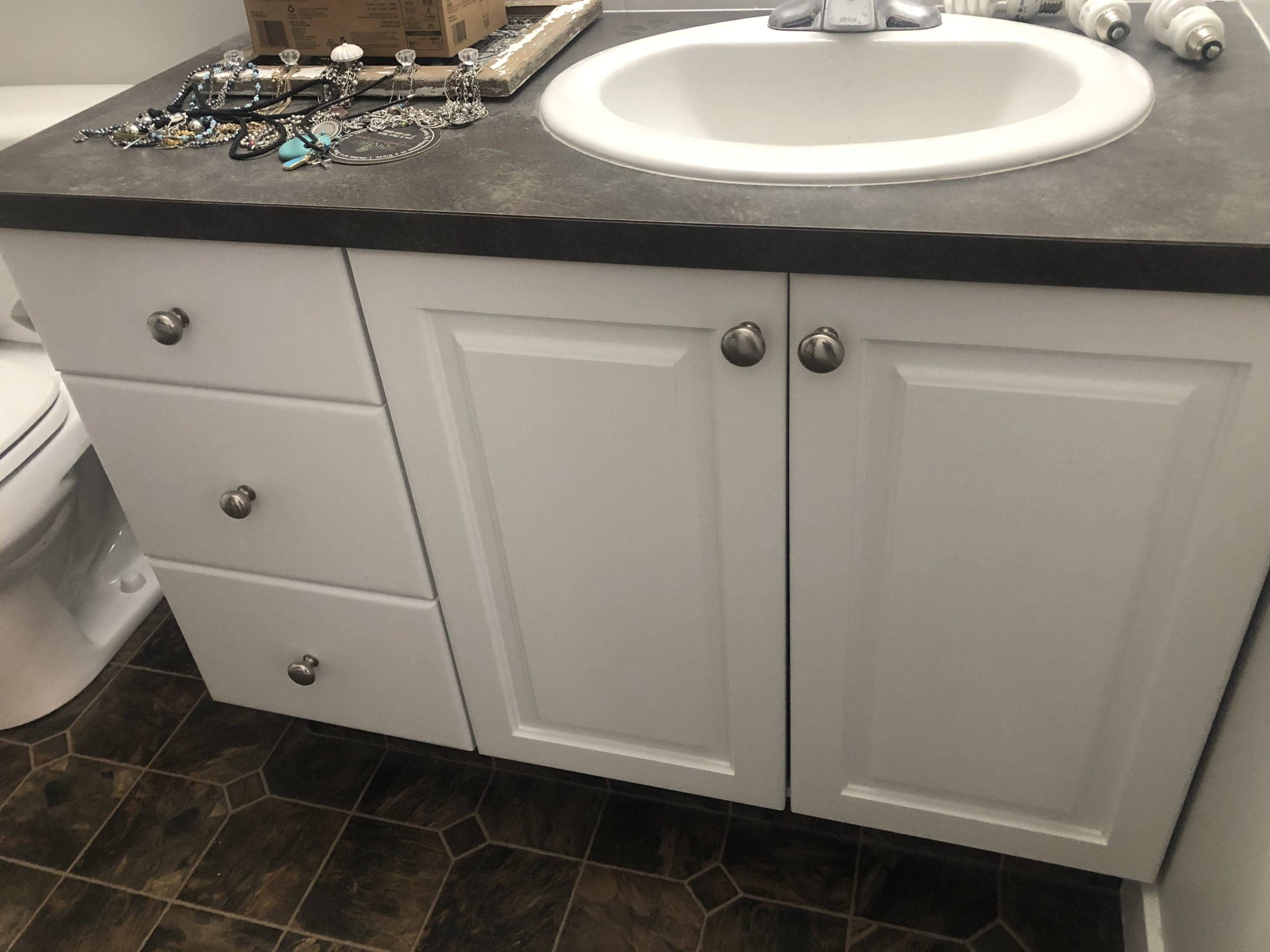 Painted white bathroom cabinetry and drawers