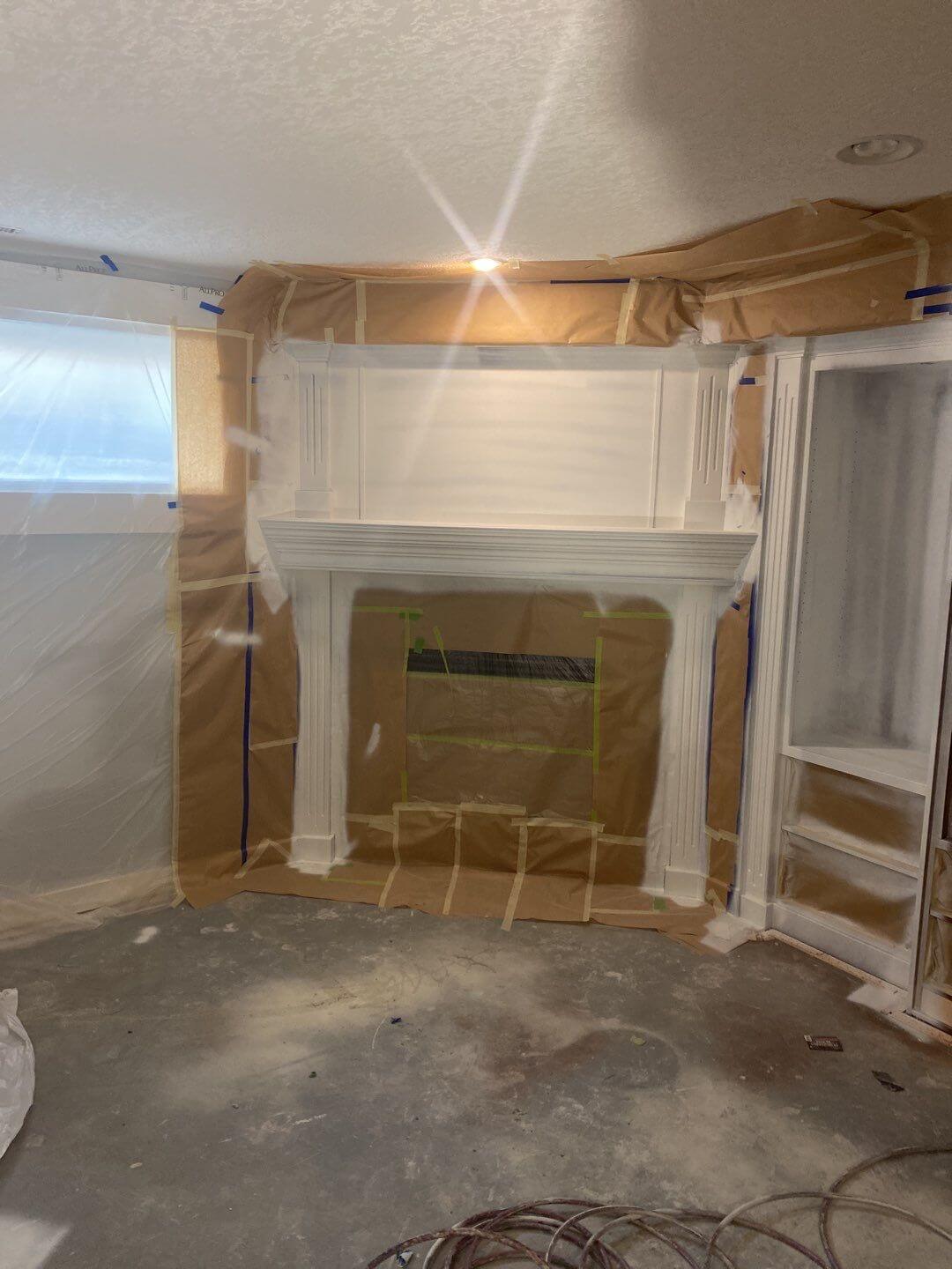 Basement fireplace mantel being sprayed modern white