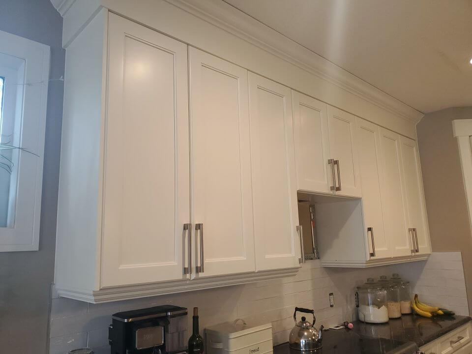 Painted white upper cabinetry with built extension to the ceiling