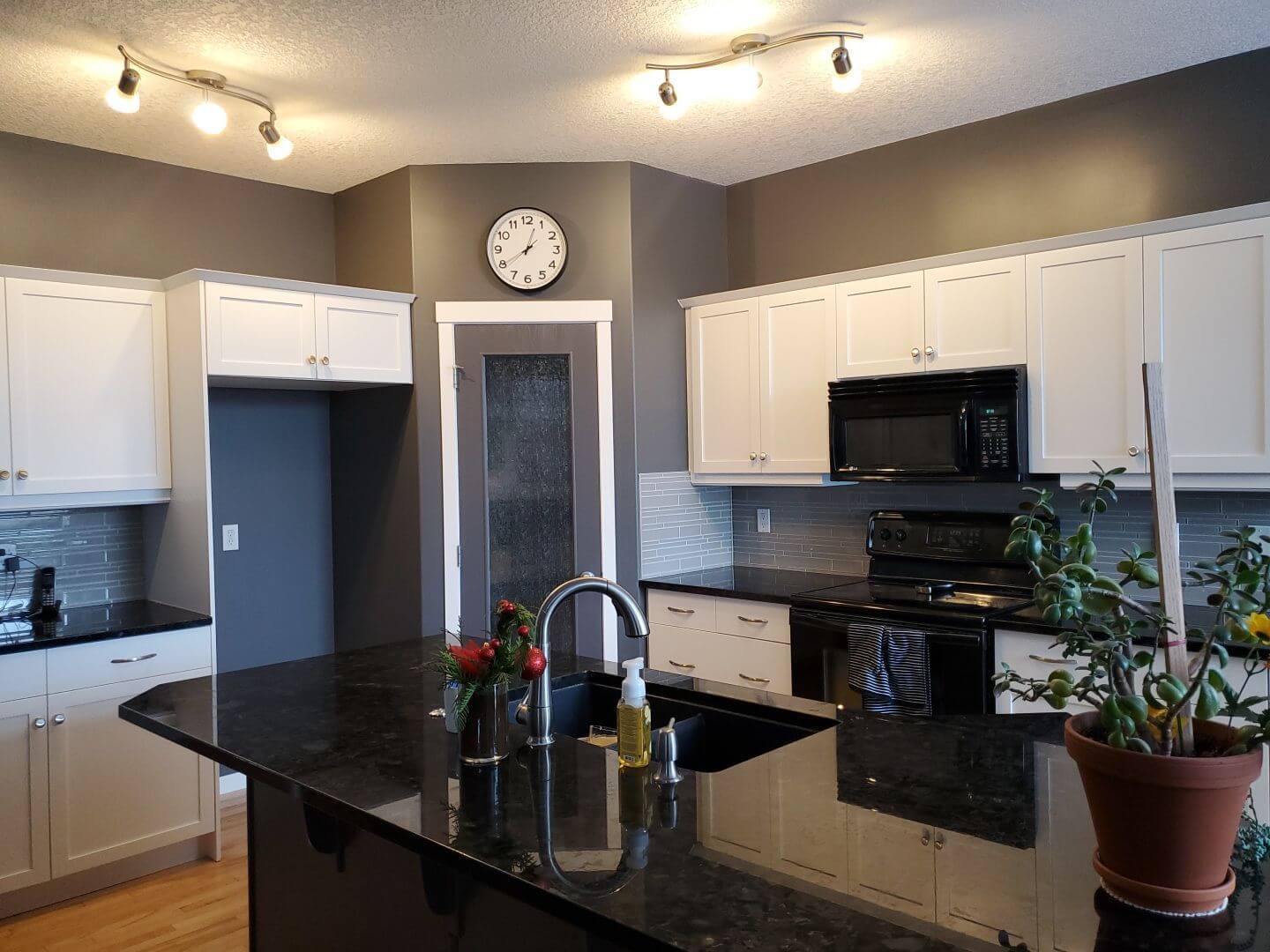 Modern white perimeter cabinetry with dark accents