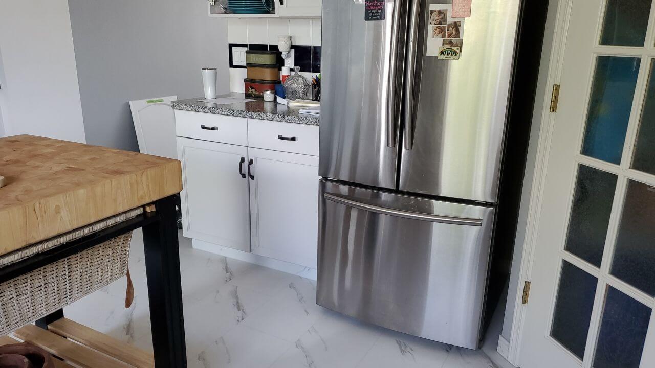 Fridge area painted side cabinetry with black handles