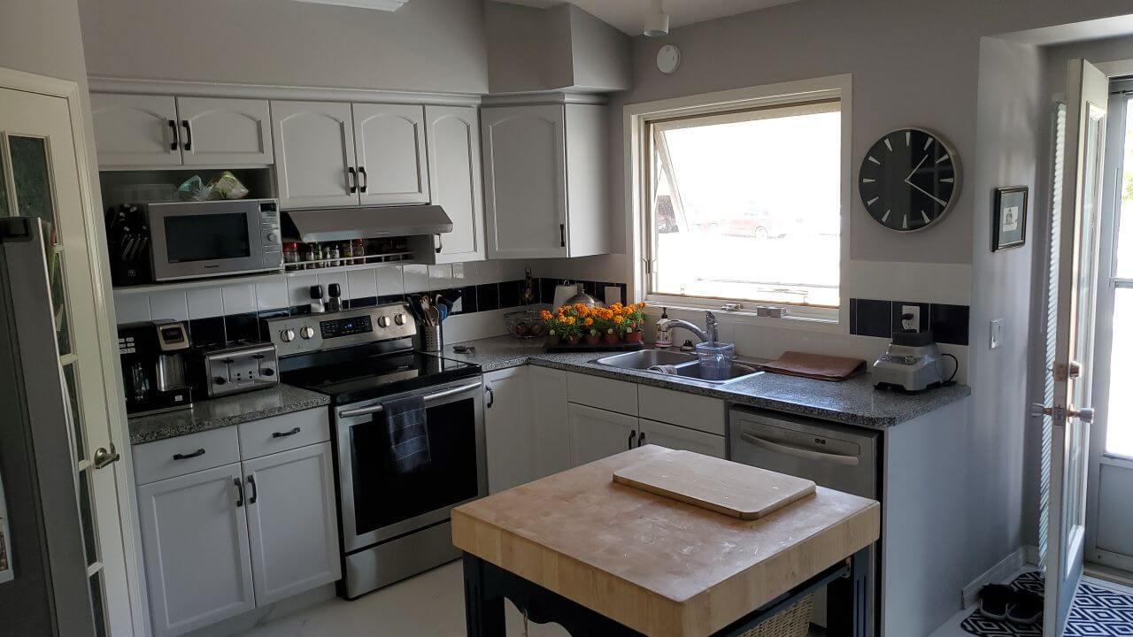 Cozy painted grey kitchen cabinetry with black accent hardware