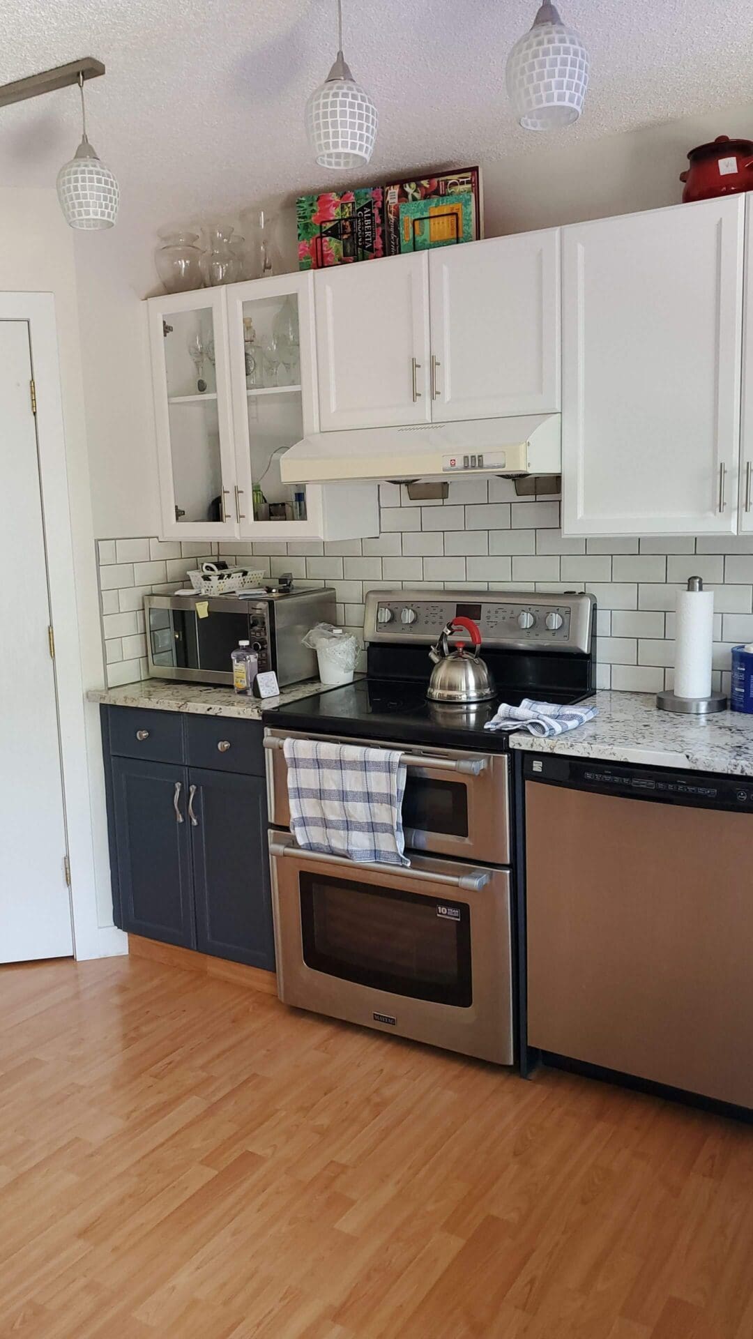 White painted glass cabinetry with navy blue accent lowers